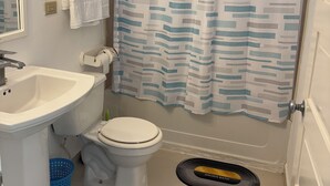 A bathroom with a white sink, toilet, and shower curtain. - Runaway Bay Caldo Tours (Runaway Bay)