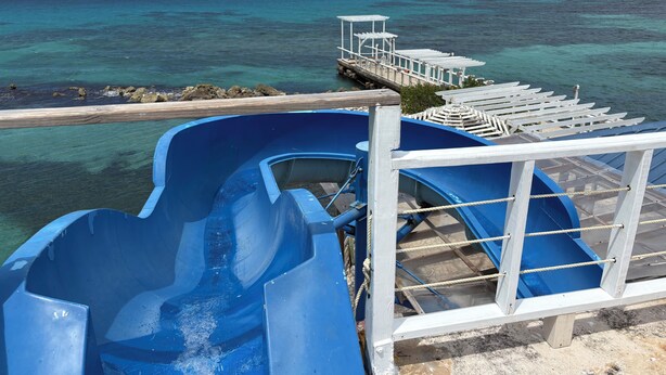 A water slide on a cruise ship deck with a view of the ocean and a dock. - Runaway Bay Caldo Tours (Runaway Bay)
