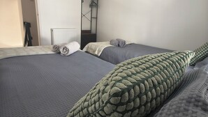 A bedroom with two beds, a radiator, and a wardrobe. - Hetton Modern Stay near Durham (Hetton-le-Hole)