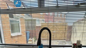 A kitchen with a black sink, a faucet, and a window with blinds. - Hetton Modern Stay near Durham (Hetton-le-Hole)
