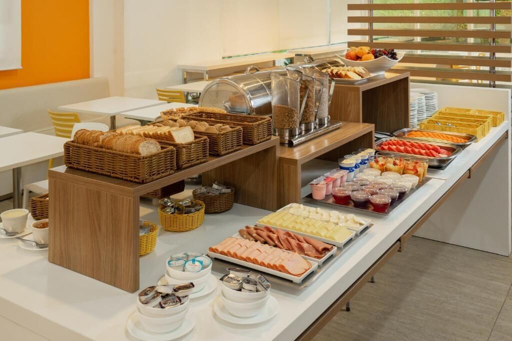 A buffet with various food items, including bread, meats, and fruits.