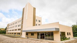 Un edificio moderno con una torre central y un cuerpo adicional de techo plano.
