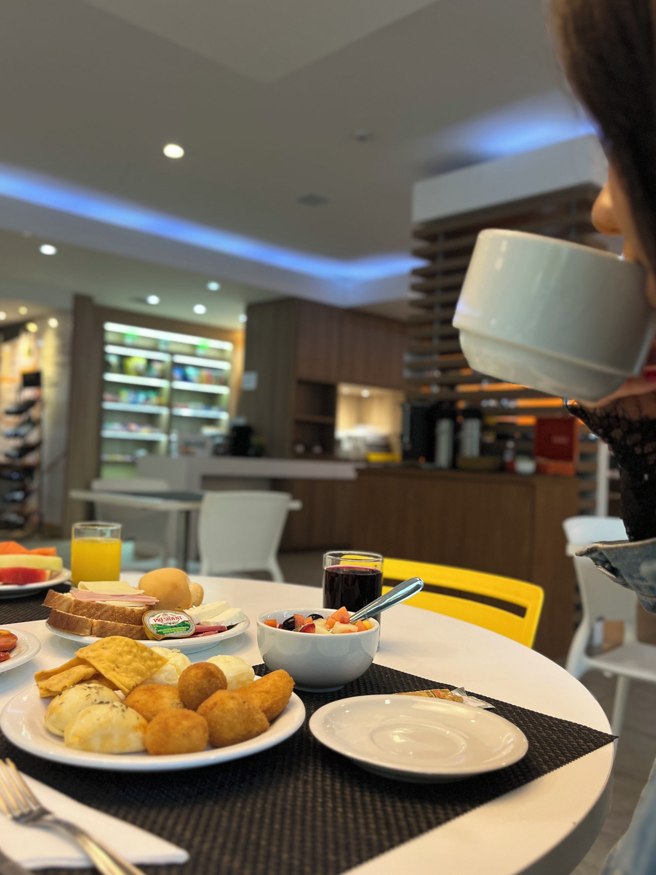 A breakfast setting with a variety of food items on a table, including toast, fruit, and a beverage.