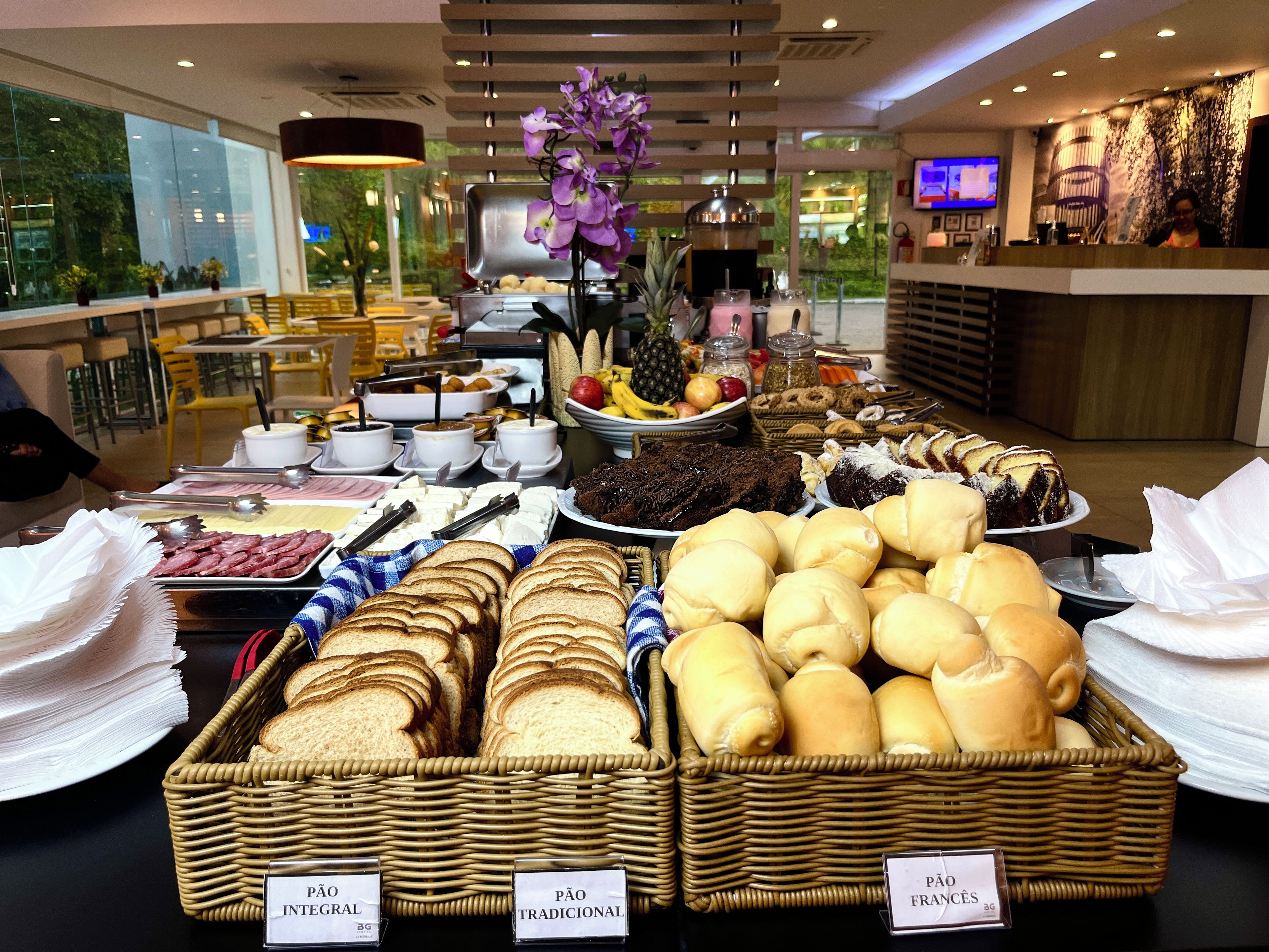 A buffet with various food items, including bread, cakes, and fruits.
