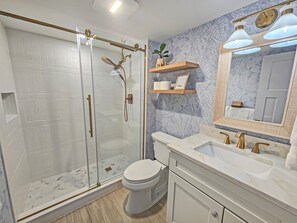 Chuveiro, secador de cabelo, toalhas de banho, papel higiênico