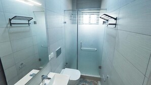 Ein modernes Badezimmer mit Duschkabine aus Glas, Toilette und Waschbecken.