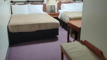A hotel room with two beds, a desk, a chair, an air conditioning unit, and a hanging coat rack.