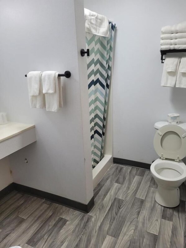 A bathroom with a shower, toilet, and sink. - Lake Stop Resort (Buffalo)