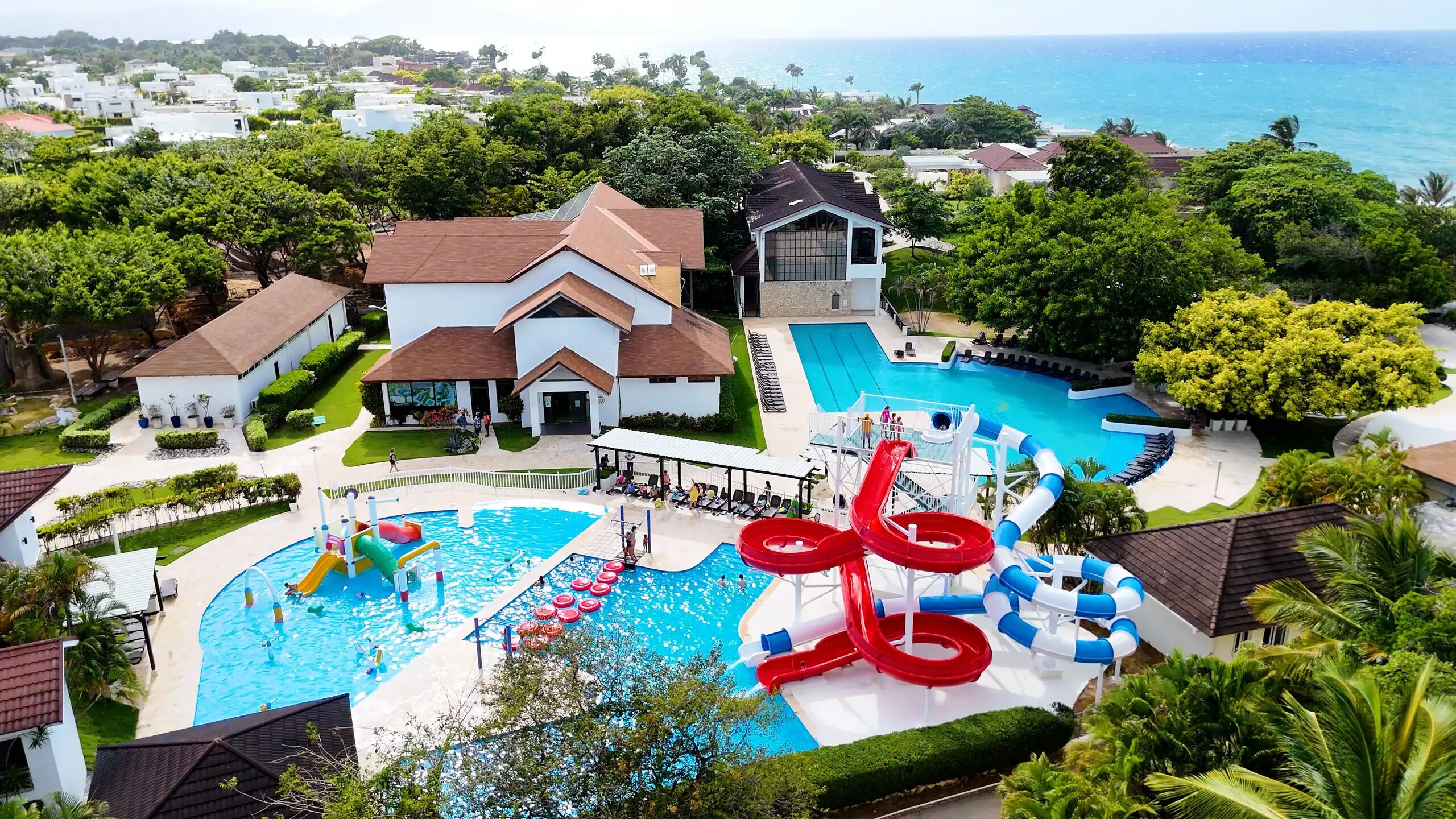 Un resort con varias piscinas, toboganes acuáticos y vista al océano.