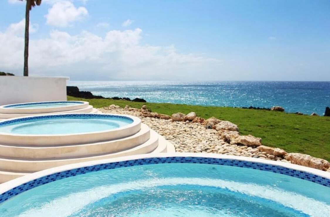 A series of hot tubs with a view of the ocean.