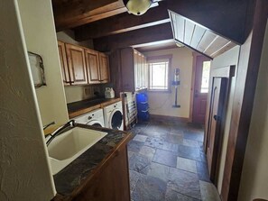 A laundry area with a washing machine, dryer, and stacked drying racks.
