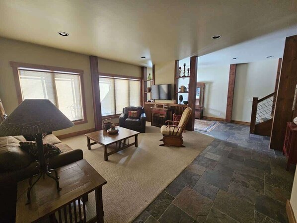 A spacious living room with a fireplace, a sofa, a coffee table, and a TV.