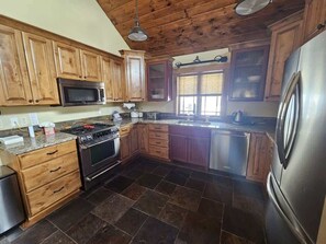 A kitchen with wooden cabinets, a stainless steel refrigerator, a microwave, a stove, and a dishwasher. - Extended stays in blissful relaxation! (Silverthorne)