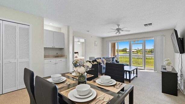 A modern apartment with a dining area, kitchen, and a balcony with a view.