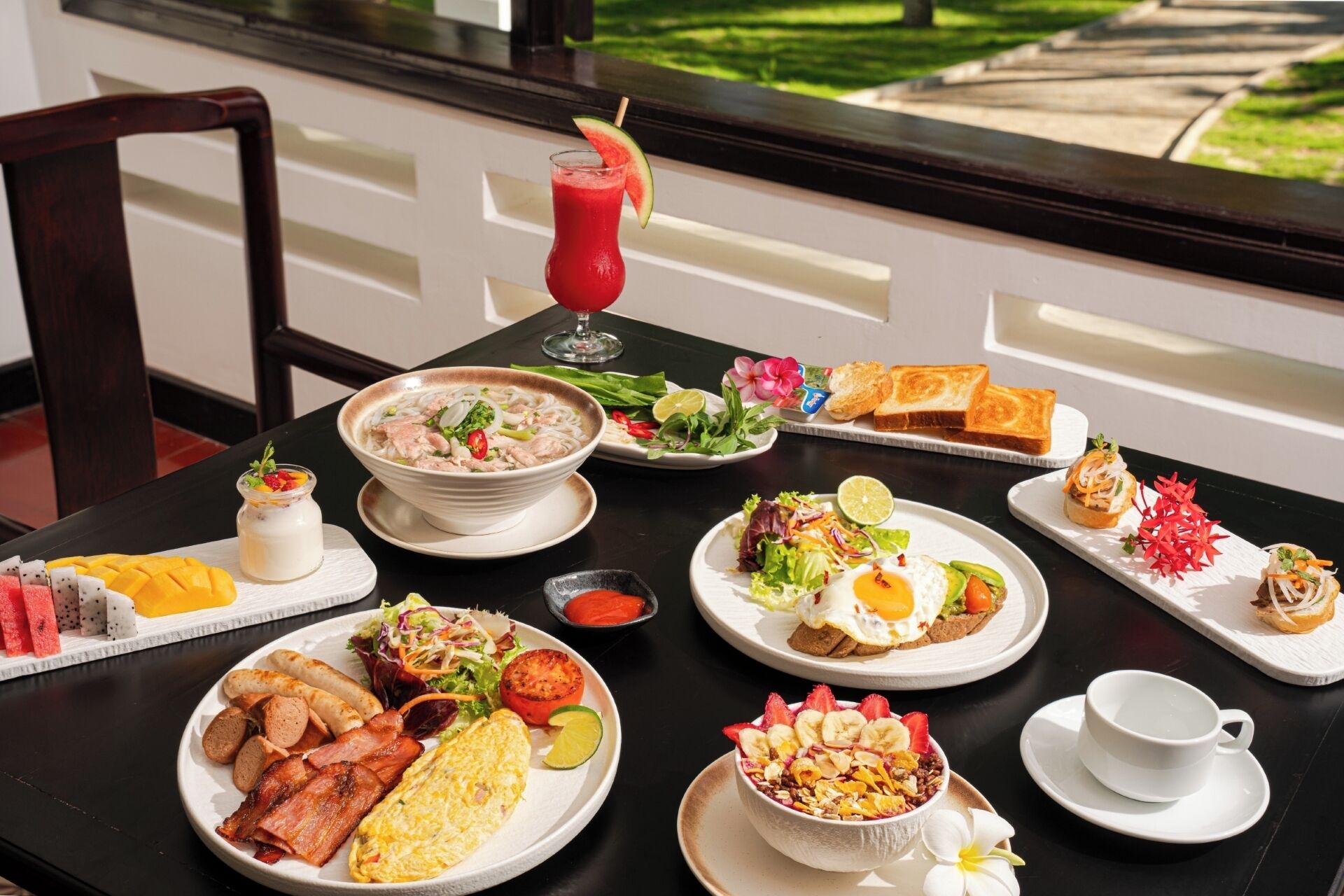 A table set with various breakfast dishes, including a bowl of soup, a salad, toast, and a fruit platter.