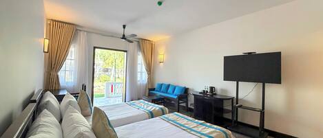 Une chambre d’hôtel avec deux lits, un bureau, une chaise, une télévision et une vue sur l’extérieur.