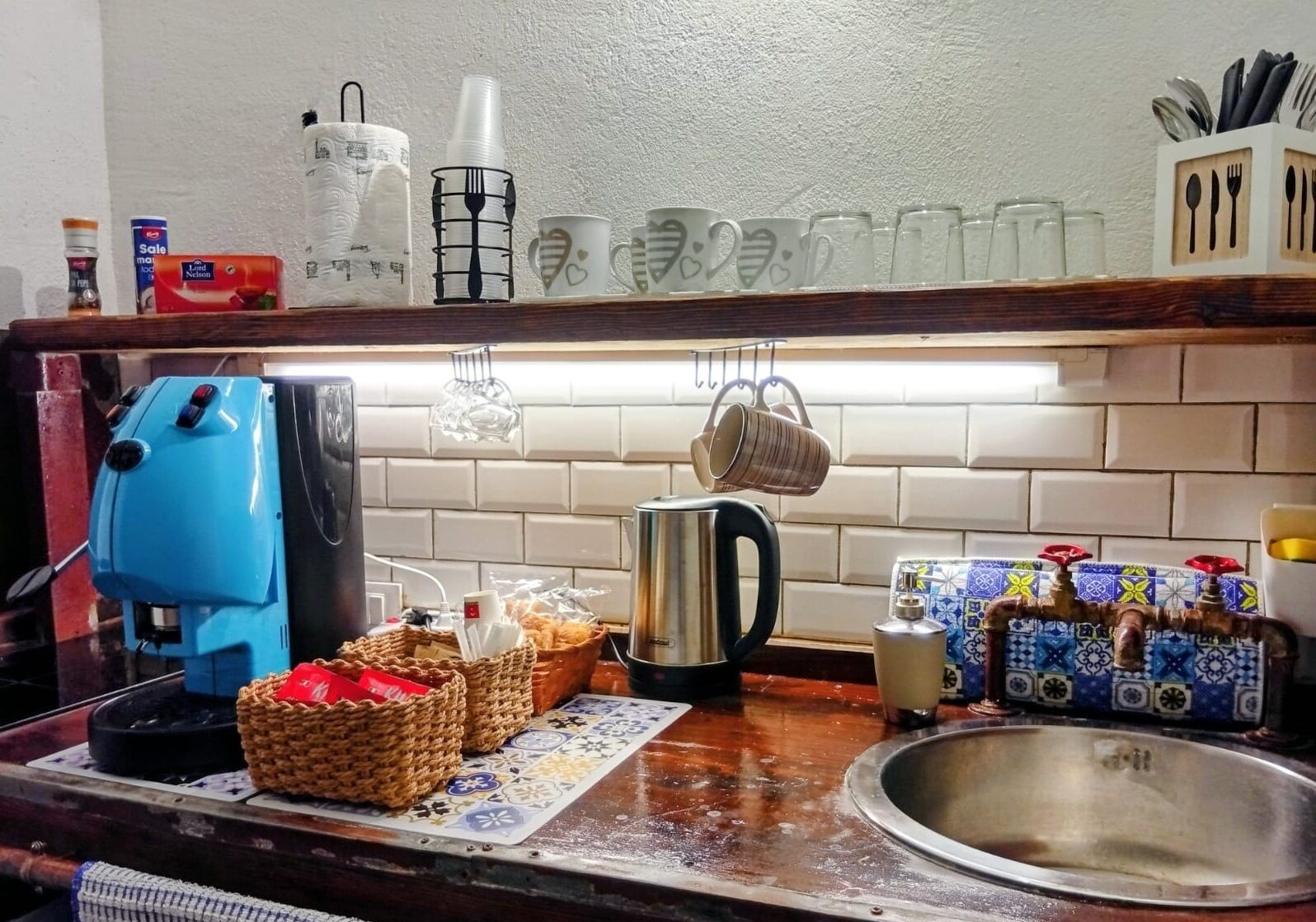 A kitchen counter with a coffee maker, a kettle, and various kitchen items.
