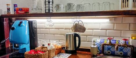 A kitchen counter with a coffee maker, a kettle, and various kitchen items.