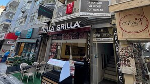 Un edificio a più piani con diversi negozi al piano terra, tra cui una pizzeria e un negozio di abbigliamento.