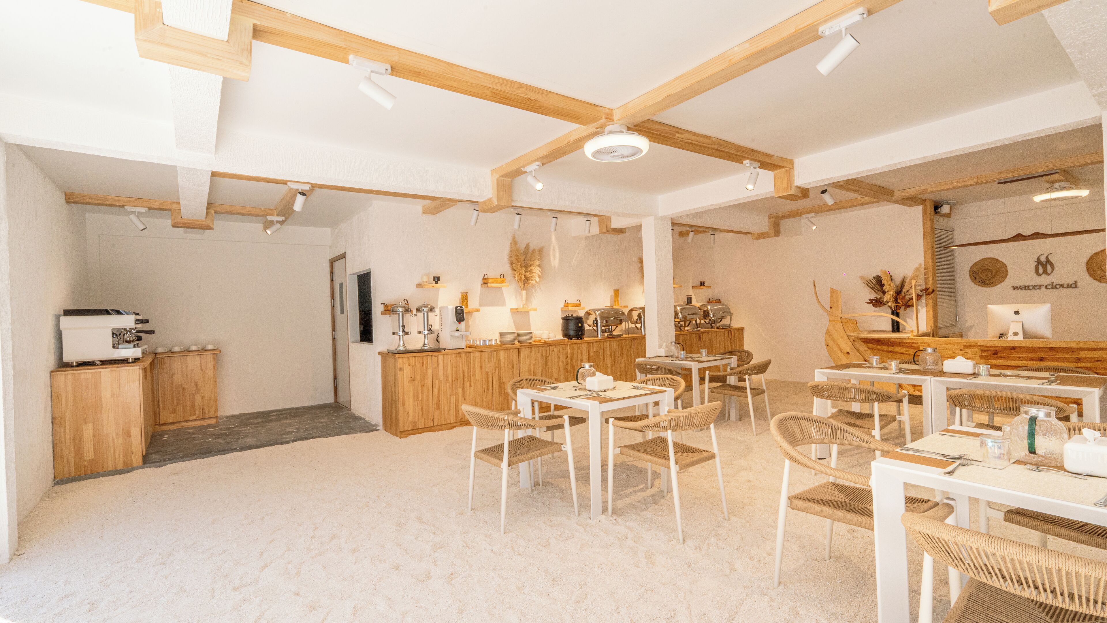 Un café con mobiliario de madera, una barra y una disposición de mesas y sillas.
