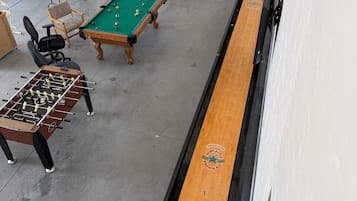 Ein Raum mit Billardtisch, Kicker und Shuffleboard.