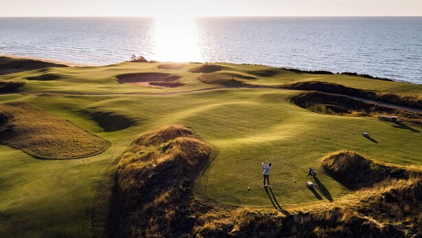 Un campo de golf con búnkeres y vistas al océano.