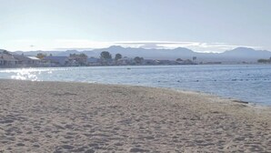 Una playa con una vista despejada de montañas al fondo.