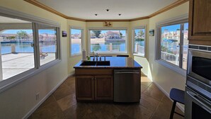Una cocina con una isla grande, lavavajillas y vistas a un lago.