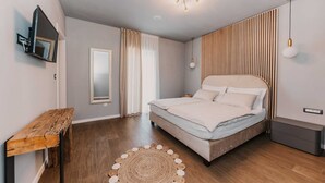 A modern bedroom with a bed, a wooden bedside table, a mirror, and a ceiling light fixture. - Villa Del Tempo with Pool (Seget Donji)