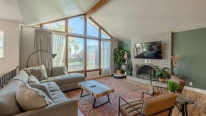 Un salón amplio con un sofá grande, una mesa de centro, una chimenea y una televisión.