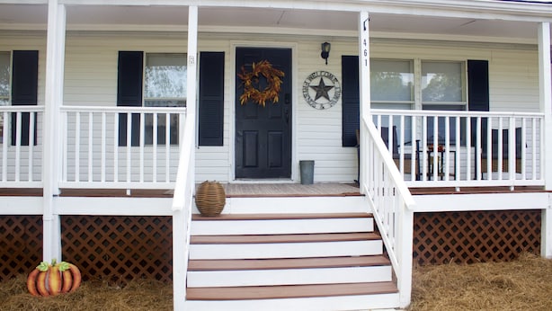 A white house with a porch, a black door, and a star decoration. - Relaxing Country Getaway – Pet Friendly, Close to Greenville & Spartanburg (Greer)