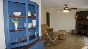 A living room with a blue cabinet, wicker furniture, and a fireplace. - Relaxing Country Getaway – Pet Friendly, Close to Greenville & Spartanburg (Greer)