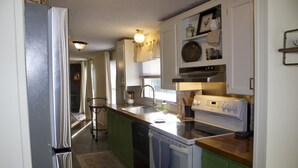 A kitchen with a refrigerator, stove, sink, and green cabinets. - Relaxing Country Getaway – Pet Friendly, Close to Greenville & Spartanburg (Greer)