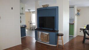 A living room with a built-in TV, a wicker basket, and a wooden stool. - Relaxing Country Getaway – Pet Friendly, Close to Greenville & Spartanburg (Greer)