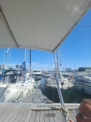 A marina with multiple boats docked, a wooden deck, and a clear blue sky. - Le Carpe Diem Year-round heated boat Close to beach and shops (Calais)