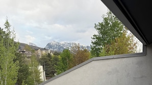 A covered outdoor seating area with a view of mountains and trees. - The House Between 2 Canyons (Cottonwood Heights)