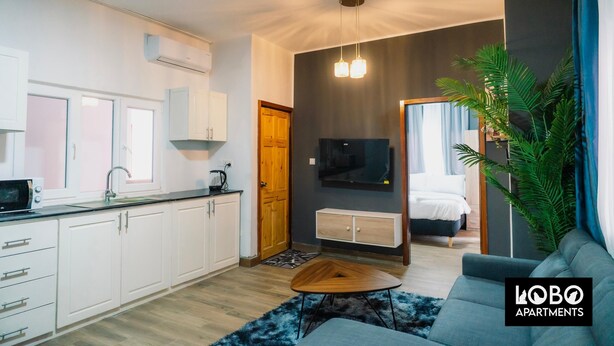 Un apartamento moderno con cocina, sala de estar y un dormitorio.