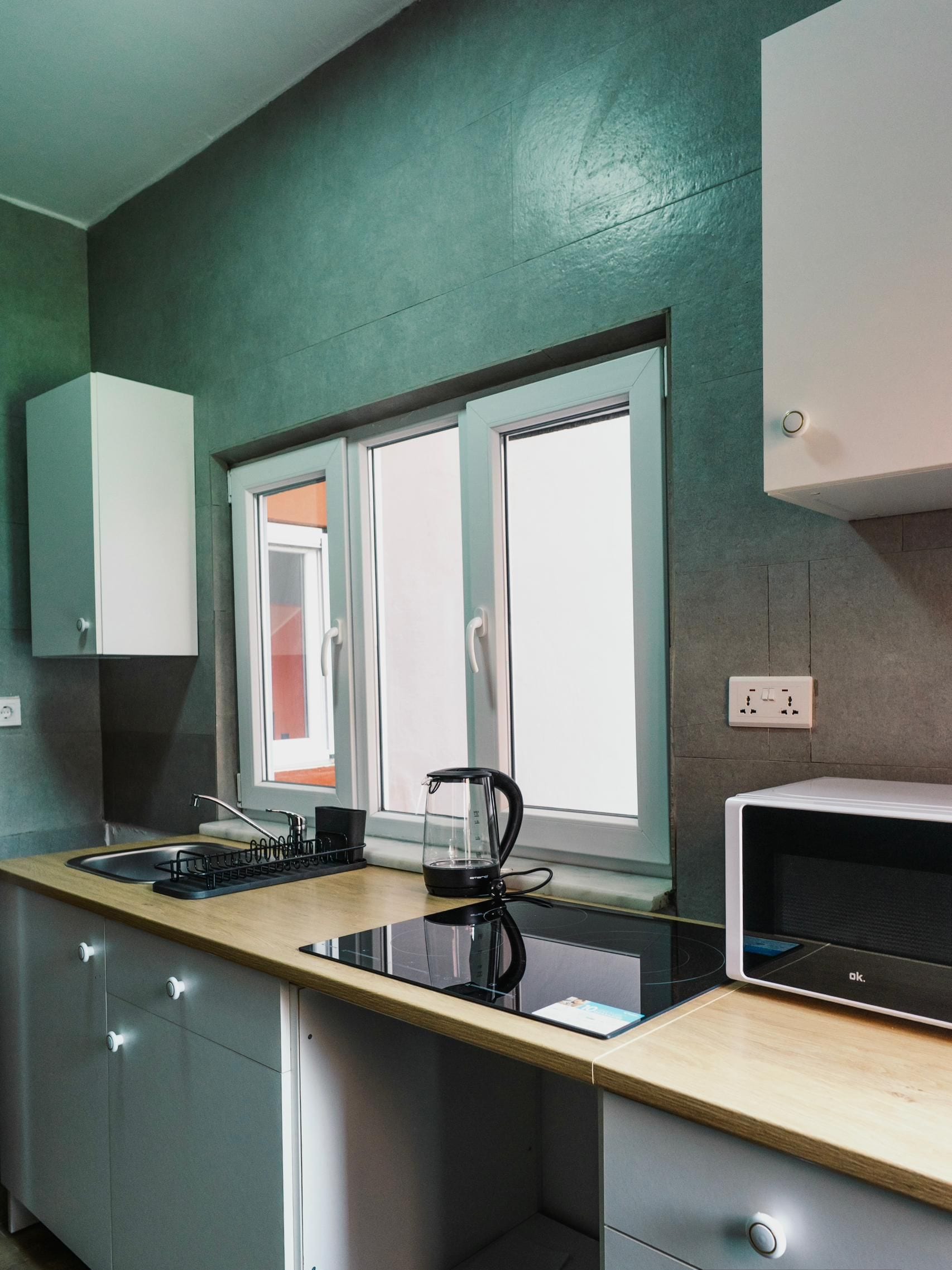Una cucina moderna con finestra, lavello e forno a microonde.