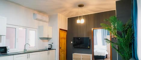 Un appartement moderne comprenant une cuisine, un espace de vie et une chambre.