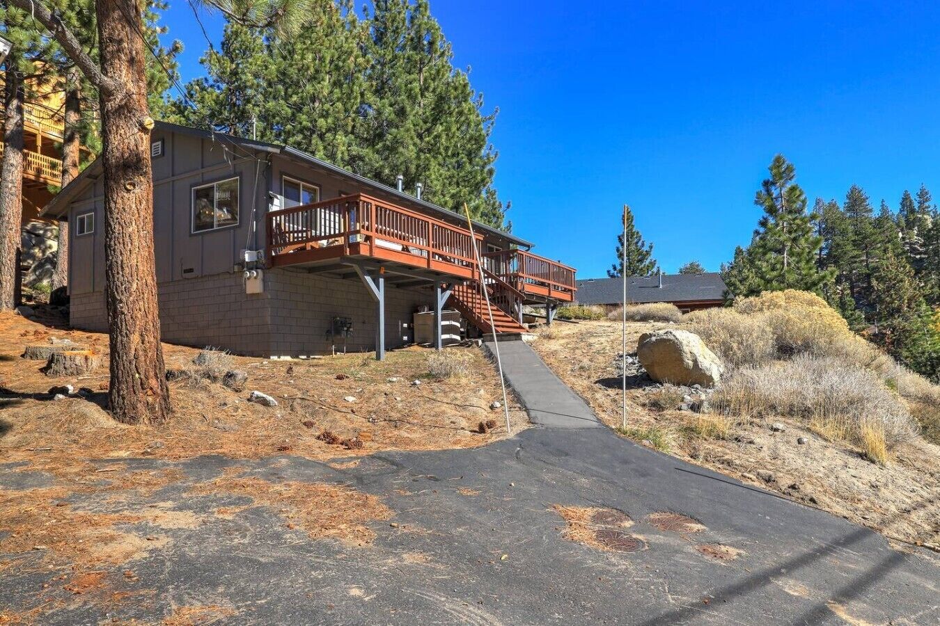 A two-story building with a wooden deck and a covered staircase.