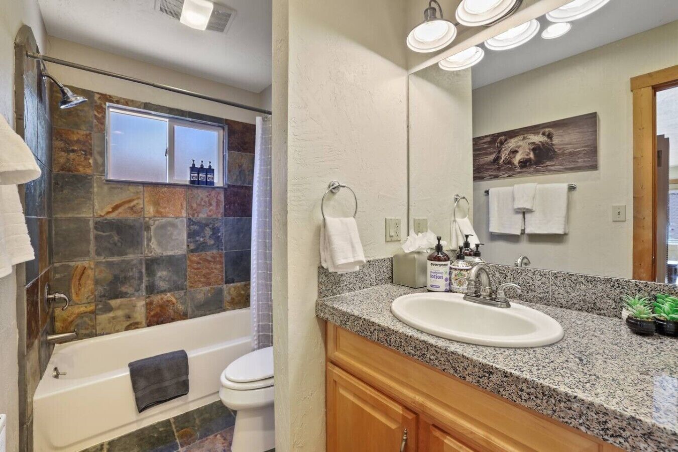 A bathroom with a bathtub, shower, and sink.