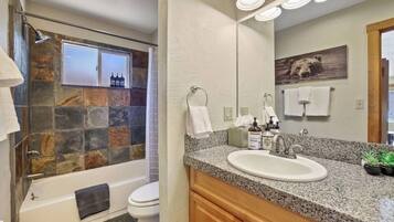 A bathroom with a bathtub, shower, and sink.