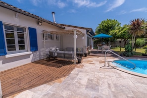 A covered patio with outdoor furniture, a pool, and a wooden deck. - Villa Zenorya (Fargues-Saint-Hilaire)