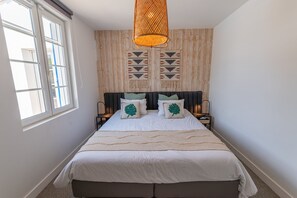 A bedroom with a bed, two nightstands, a hanging light fixture, and a window. - Villa Zenorya (Fargues-Saint-Hilaire)