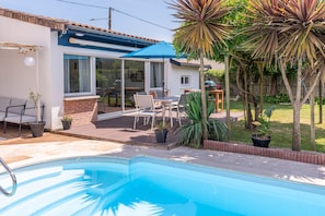 A residential backyard with a swimming pool, patio furniture, and a covered seating area. - Villa Zenorya (Fargues-Saint-Hilaire)