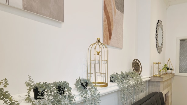 A living room with a fireplace, a black leather sofa, and a white armchair. - Ramblei near Rittenhouse Sq / 1 bedroom – Unit A (Philadelphia)