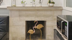 A modern living room with a fireplace, a decorative mirror, and a small plant arrangement. - Ramblei near Rittenhouse Sq / 1 bedroom – Unit A (Philadelphia)