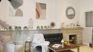 A living room with a fireplace, a sofa, a coffee table, and decorative items. - Ramblei near Rittenhouse Sq / 1 bedroom – Unit A (Philadelphia)