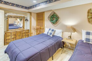 Una camera da letto con un letto grande, una cassettiera in legno, uno specchio e una pianta fissata al muro.