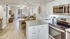 A kitchen with white cabinets, a stainless steel microwave, and a double oven. - Access to Folly Field Beach & Pools: Coastal Condo (Hilton Head Island)